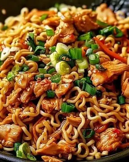Bowl of Chicken Ramen Stir Fry garnished with green onions and vegetables