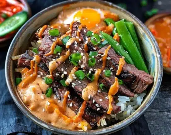 Delicious Korean BBQ steak rice bowl garnished with fresh vegetables.