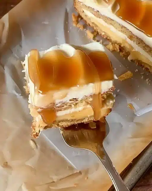 Slice of moist Caramel Apple Cake topped with caramel drizzle and apple slices.