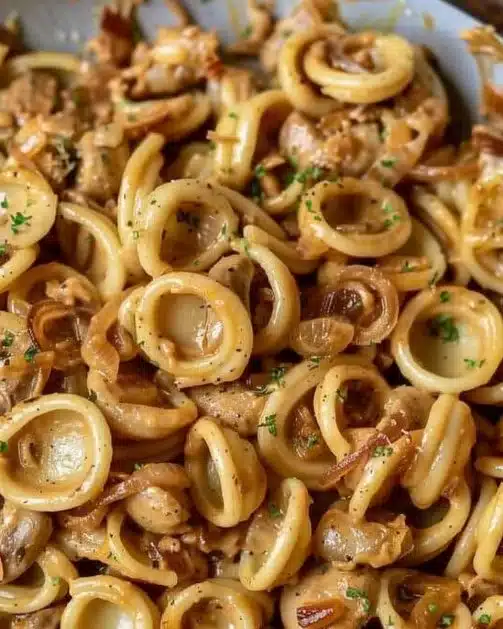Delicious bowl of caramelized onion pasta garnished with herbs
