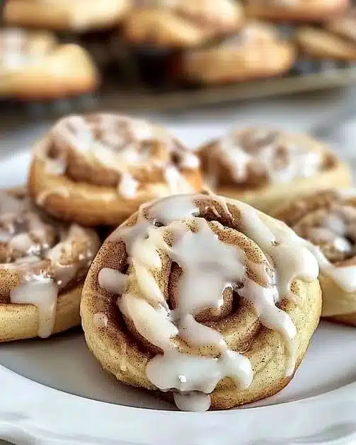 Delicious cinnamon roll cookies topped with icing on a wooden table
