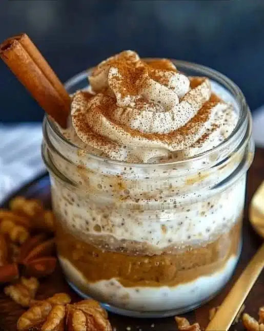 Bowl of cinnamon roll overnight oats topped with cinnamon and maple syrup