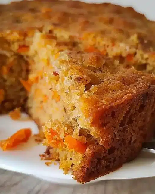 Slice of easy flourless oatmeal carrot cake topped with cream cheese frosting