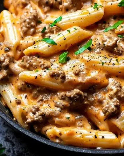 Creamy beef pasta dish with high protein, served in a bowl, garnished with herbs.