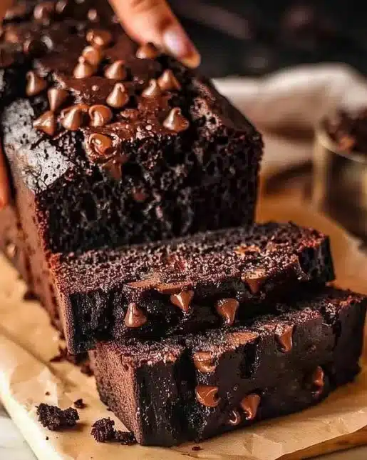 Moist chocolate pumpkin bread sliced and served on a rustic wooden table.