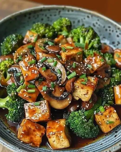 Stir-fried mushroom and tofu served with colorful vegetables in a bowl.