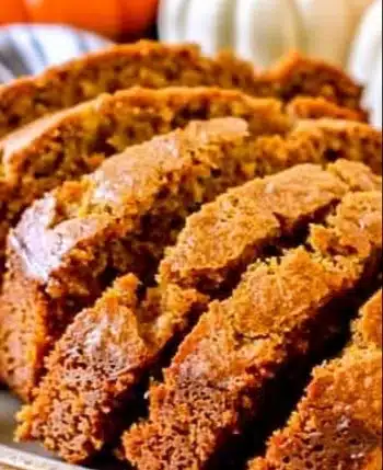 Homemade pumpkin bread loaf with spices and pumpkin chunks, perfect for fall baking.
