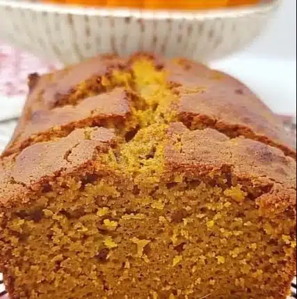 Slice of moist homemade pumpkin bread with spices and walnuts