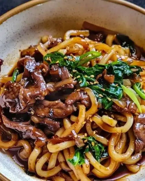 Delicious black pepper beef udon noodles garnished with green onions