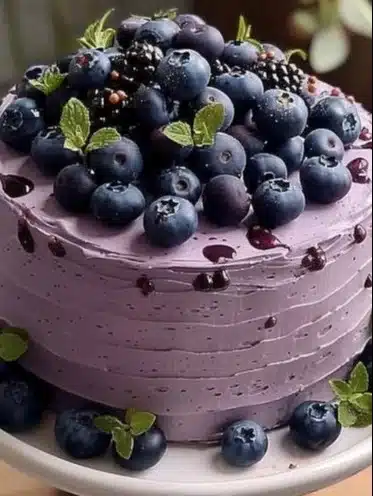 Delicious blueberry chiffon cake topped with fresh blueberries and whipped cream.