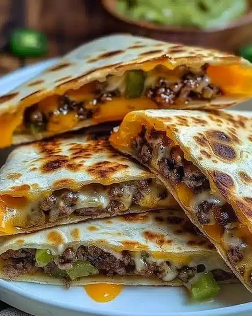 Melted cheeseburger quesadilla served with toppings and dipping sauce