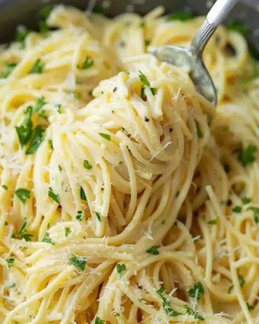 Creamy one-pot garlic parmesan pasta dish garnished with parsley and parmesan cheese.