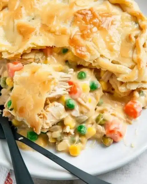 Easy chicken pot pie casserole topped with flaky crust and fresh vegetables
