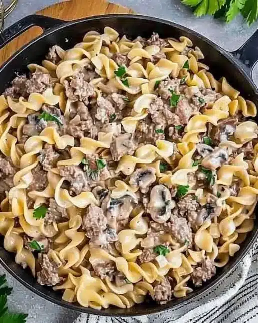 Delicious easy Ground Beef Stroganoff served with pasta and garnished with parsley.