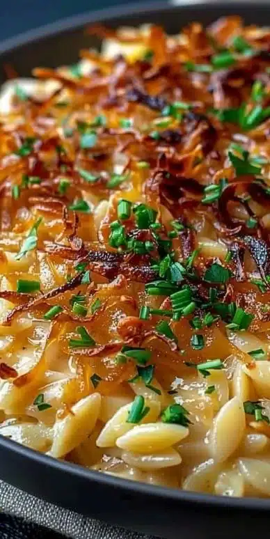 French Onion Chicken Orzo Casserole topped with melted cheese and herbs