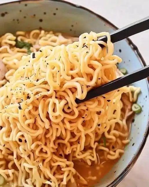 Delicious garlic butter ramen noodles topped with herbs and sesame seeds