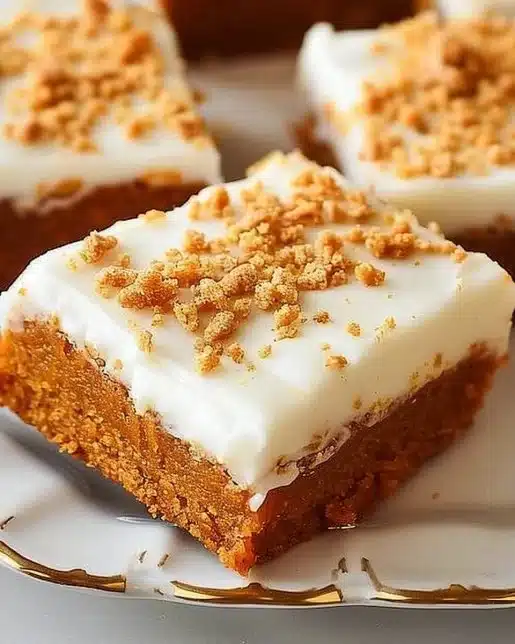 Delicious pumpkin bars with cream cheese frosting on a rustic wooden table