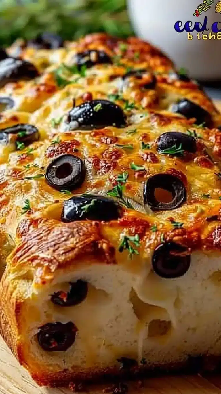 Sliced gooey olive cheese bread topped with melted cheese and olives.