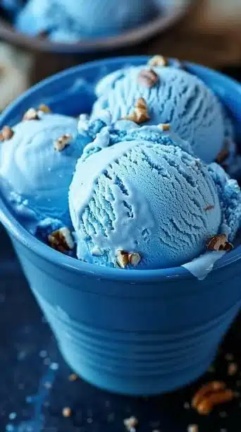 A scoop of Blue Moon Ice Cream in a cone, showcasing its vibrant blue color.