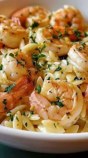 Lemon Butter Garlic Shrimp Orzo in a skillet, garnished with herbs